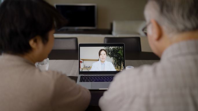 老年夫妇与女医生通过电脑进行视频通话