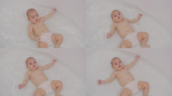 有趣的新生儿在洗澡时游泳