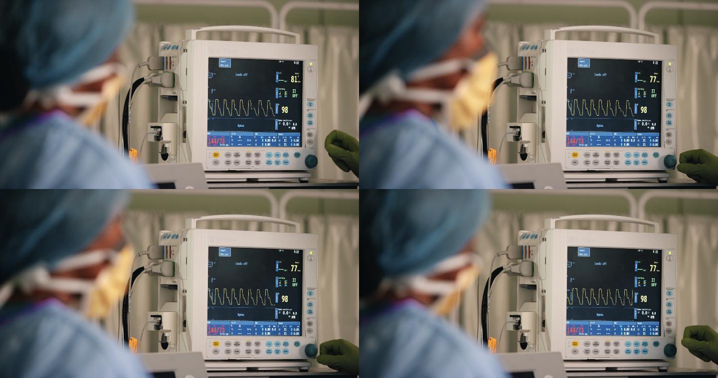 外科医生按下心率监视器上的按钮
