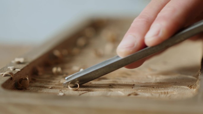 木雕师用凿子加工核桃木板