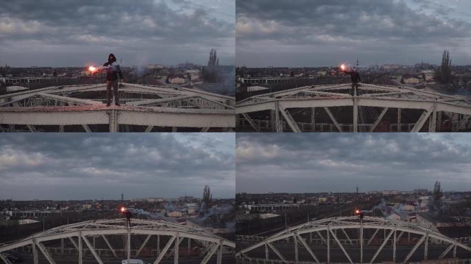 男人拿着信号灯在钢架桥顶部的鸟瞰图