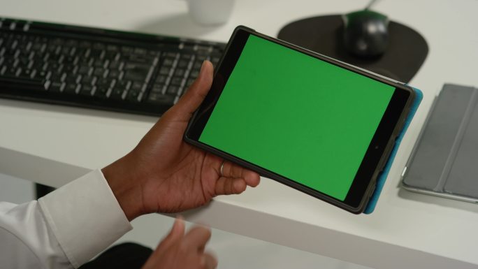 特写男子在绿色屏幕平板电脑上滑动