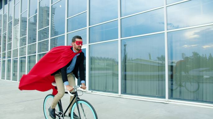 超级英雄商人在城市街道商业区骑自行车