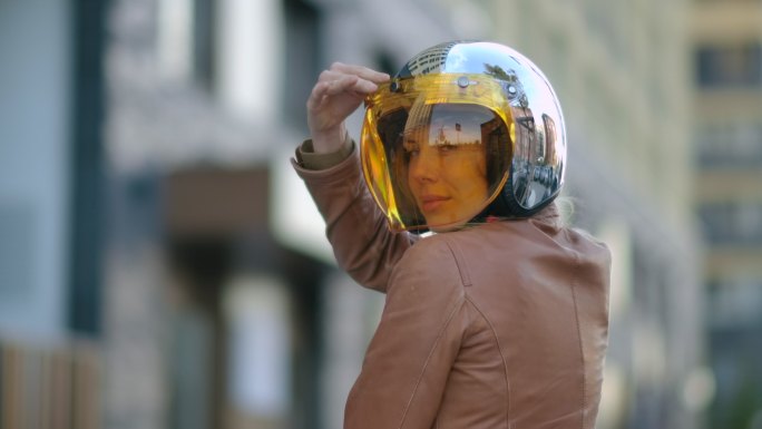 身穿皮夹克、戴着摩托车头盔的女人