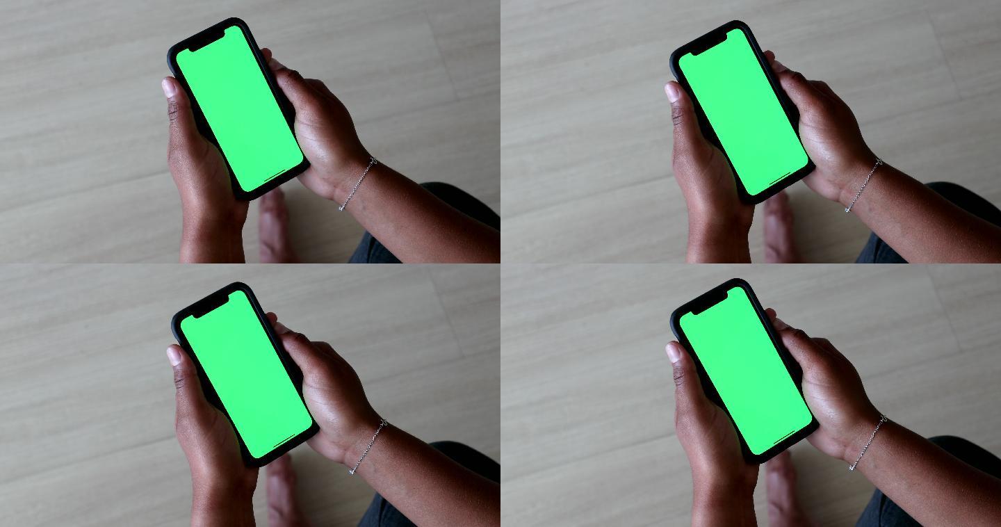 女子手持绿色屏幕手机