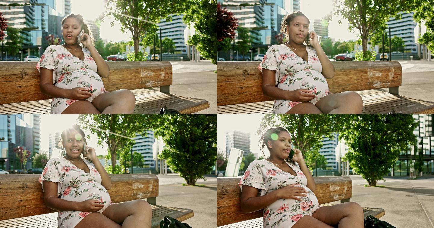 怀孕女人坐在公园长椅上使用智能手机