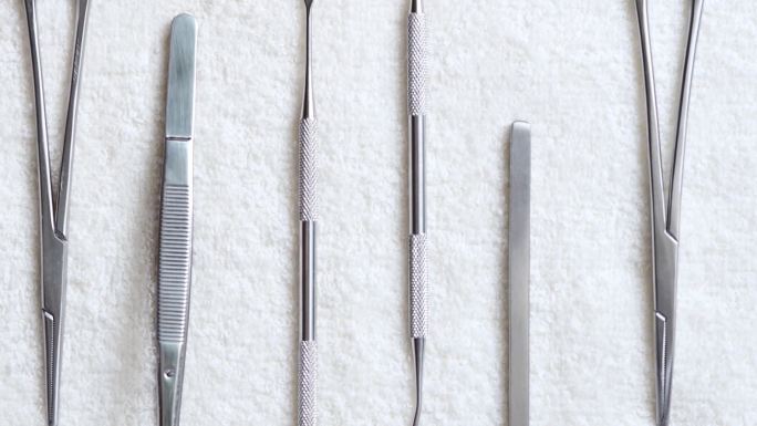 白色餐巾上的牙科工具。