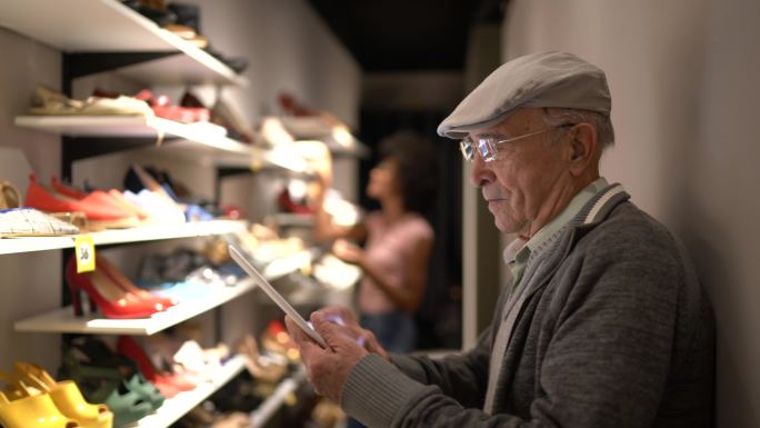 老人在鞋店使用数字平板电脑