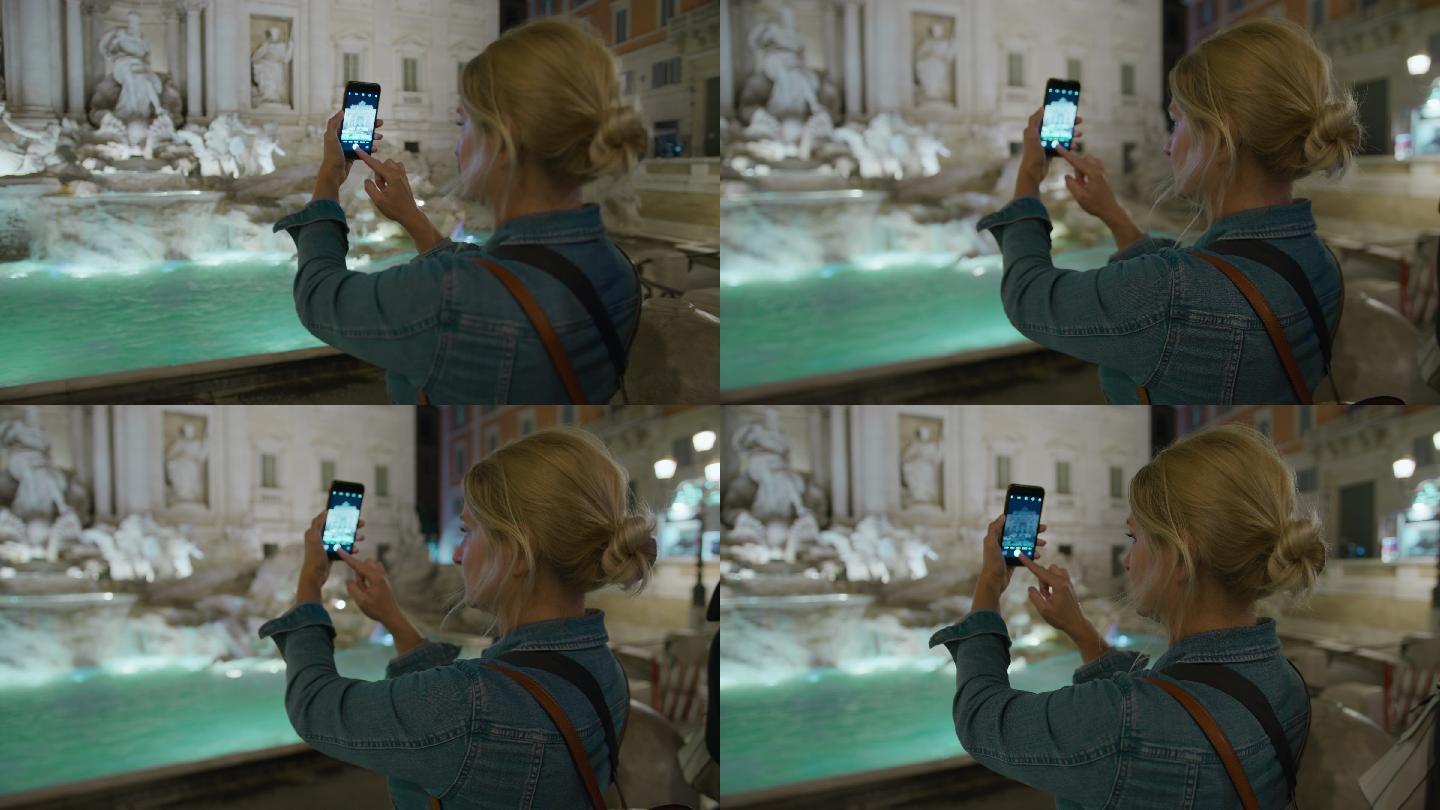 游客使用智能手机拍摄特雷维喷泉