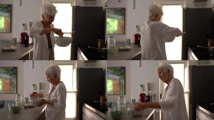 在家里的厨房里做饭跳舞的老妇人