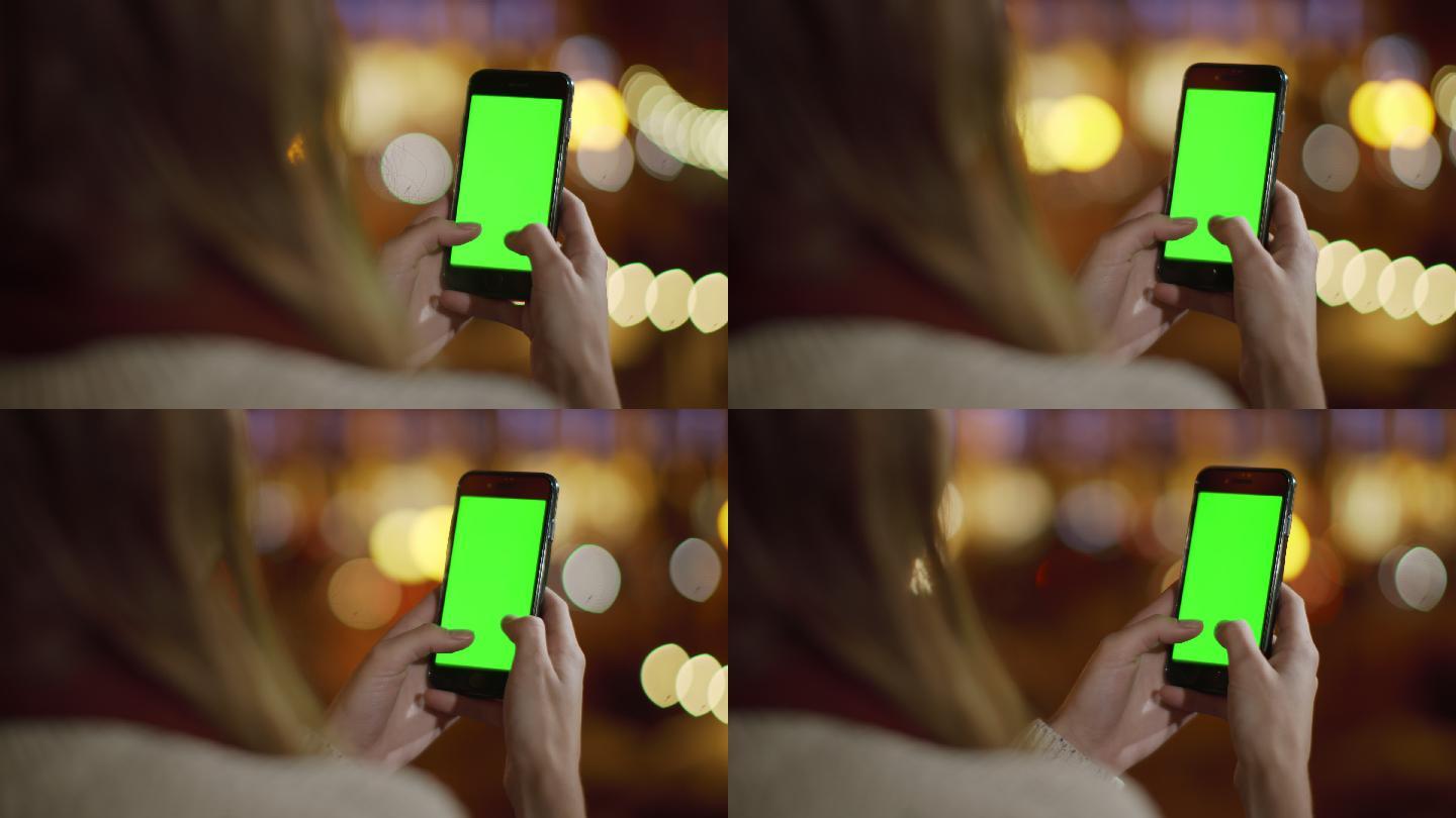 背视女孩使用手机绿色屏幕