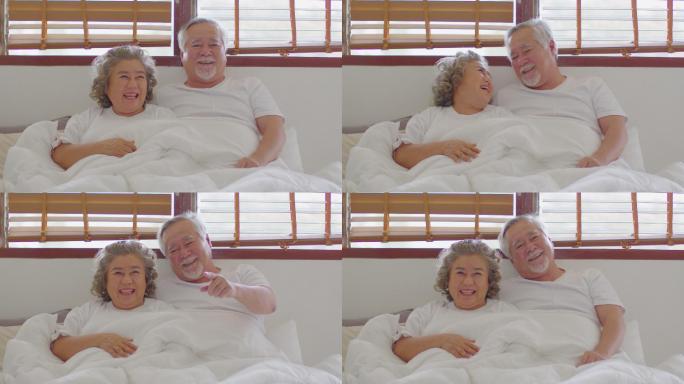 幸福的夫妇躺在床上笑嘻嘻