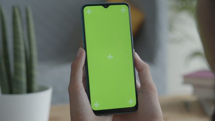 女性手中的绿色屏幕智能手机