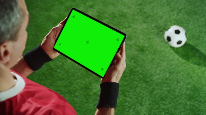 足球运动员使用绿色屏幕平板电脑