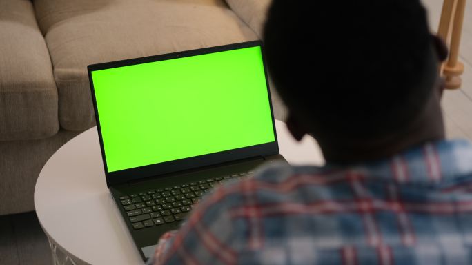 男子使用带有绿色屏幕的电脑进行视频聊天