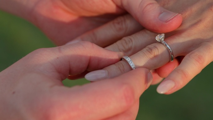 在婚礼上，新郎为新娘戴戒指