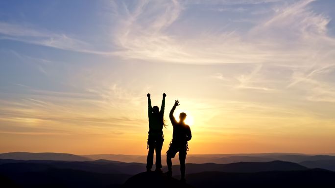 年轻夫妇站在山顶上高兴地举手