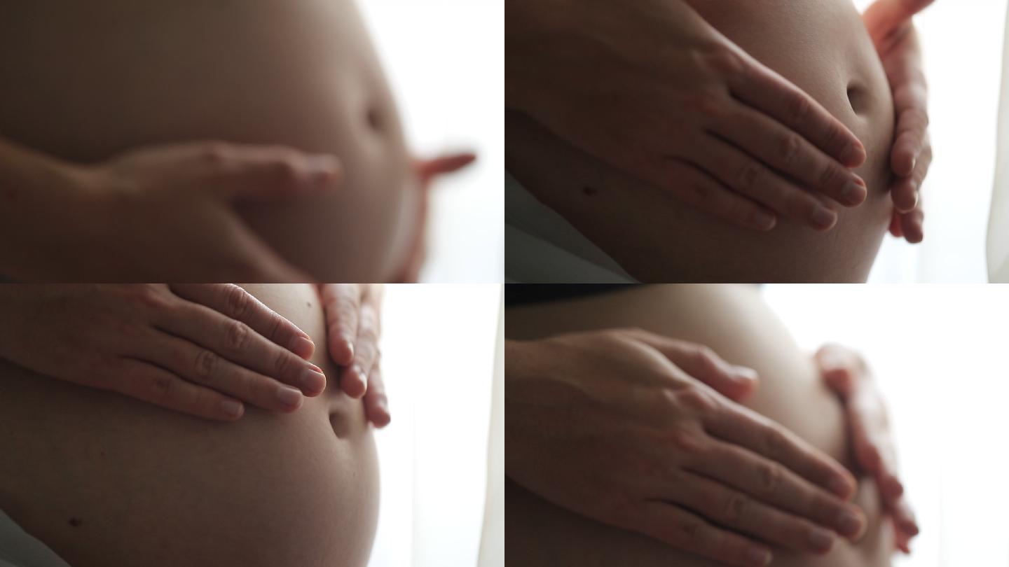 孕妇双手抚摸腹部的宏观特写