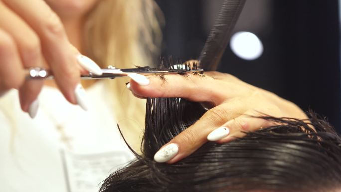 专业理发师用薄剪刀剪掉客户的头发