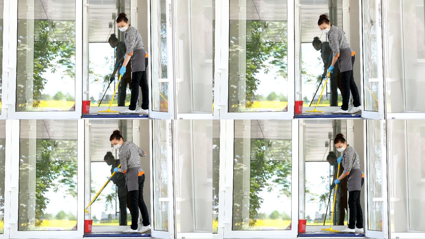 女清洁工在餐厅或公共机构入口处打扫