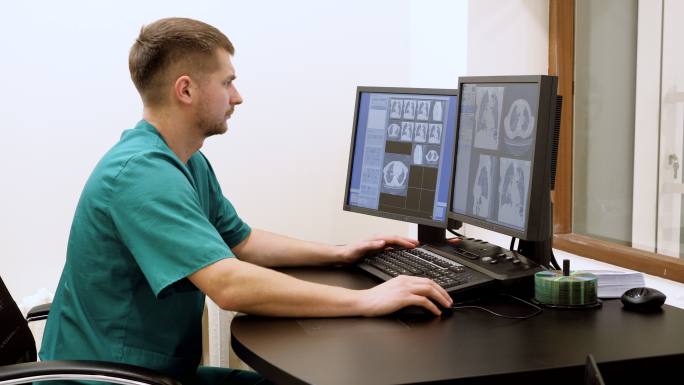 医生在电脑屏幕上查看病人的扫描结果
