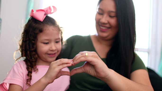 母亲和孩子用手做心形符号