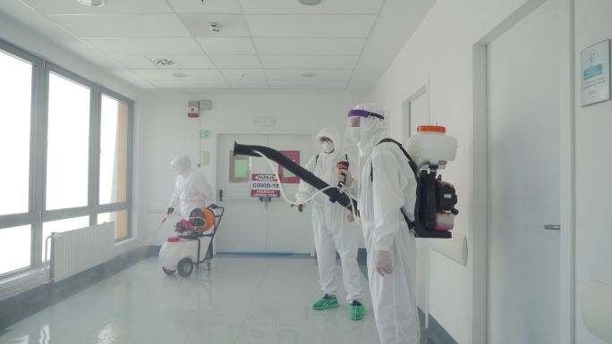 穿着防护服的人群在医院区域的消毒室