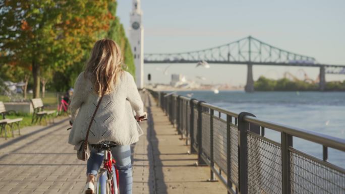 女子在蒙特利尔旧港骑自行车。