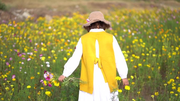 女孩手抚鲜花花海中行走