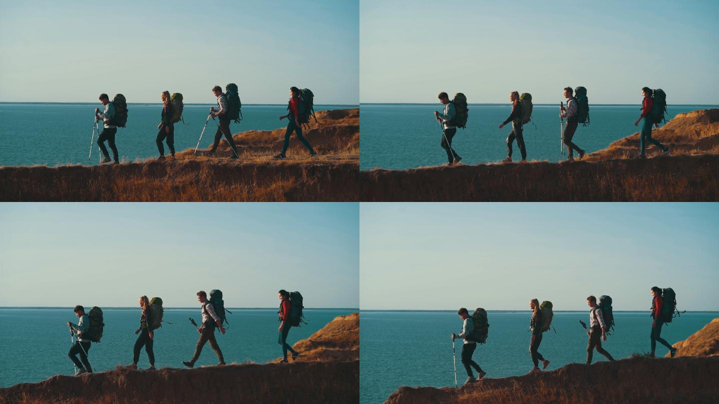 四个徒步旅行者在海边的山上行走。