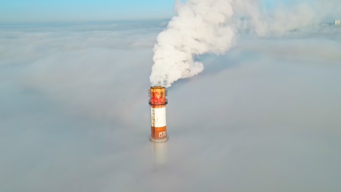 低云上方冒出烟雾的热力站管道。