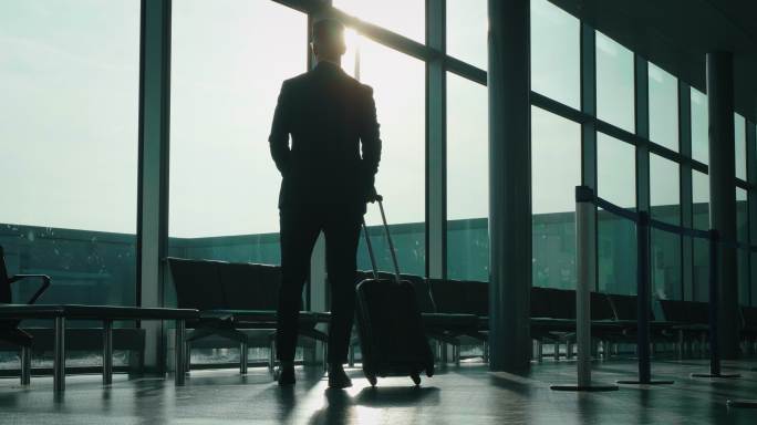 商人着手提箱在国际机场慢步走着