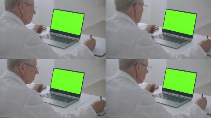 医生使用绿色屏幕的笔记本电脑