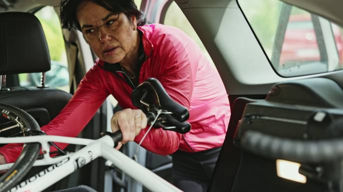 女性自行车手将自行车固定在车后