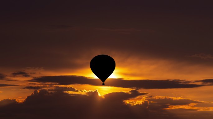 在美丽的日落天空中乘气球飞行
