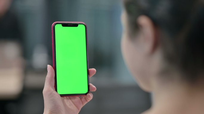 女性使用带有绿色屏幕的智能手机