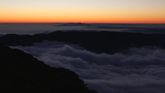日落时山顶上雾气笼罩的壮丽景色。