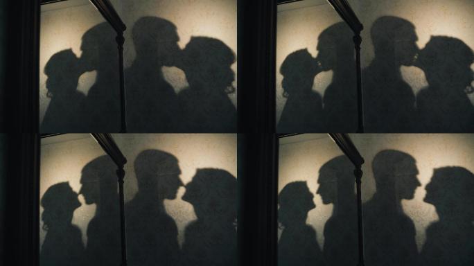 亲吻的夫妇影子灯光玻璃窗