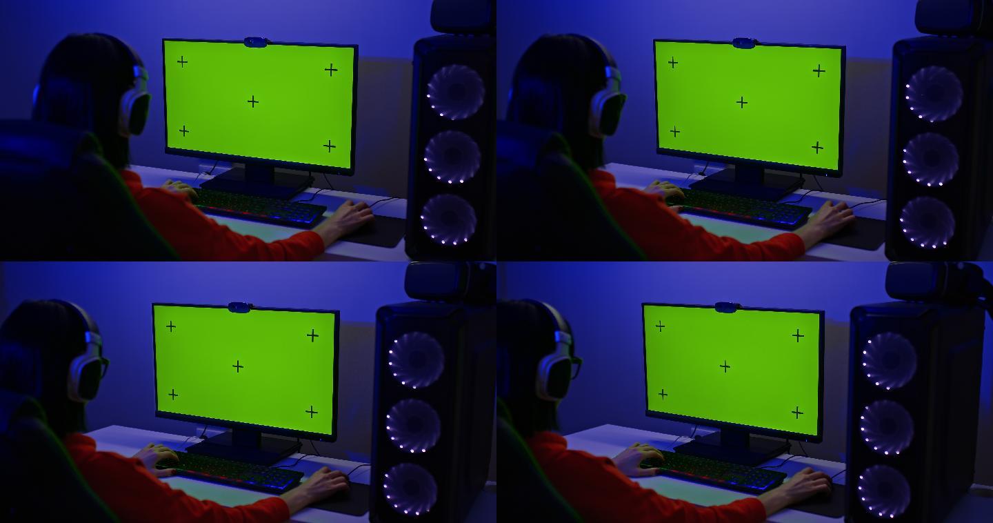 玩家坐在一个绿色屏幕的大电脑显示器前