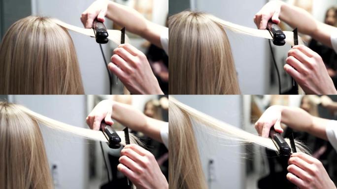 美发师用直发器给女人的长发定型