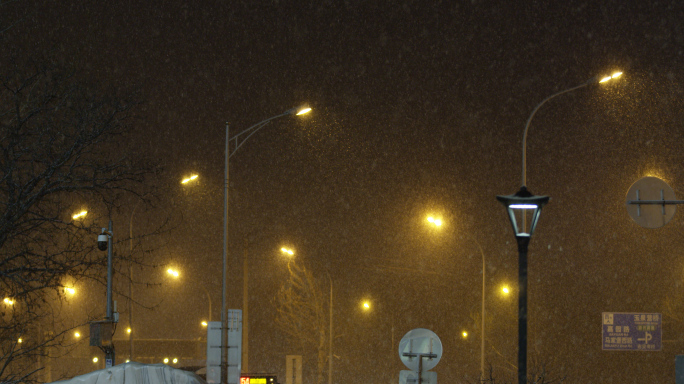 下雪街道北京深夜路灯，加班雪中忙碌的人