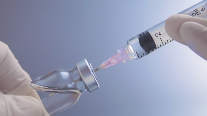 从玻璃瓶中取出疫苗的注射器