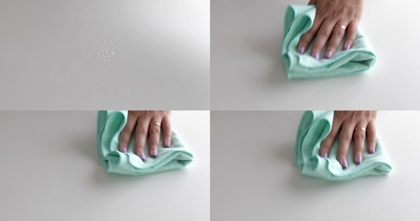 女人用布手工擦拭白色表面