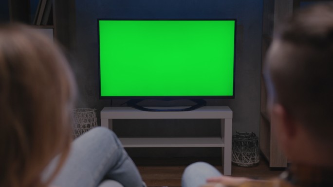 一家人坐在客厅的沙发上一起看绿屏电视模型