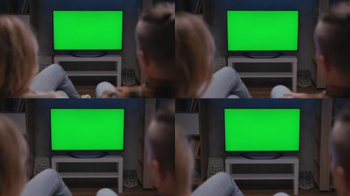 一家人坐在客厅的沙发上一起看绿屏电视模型