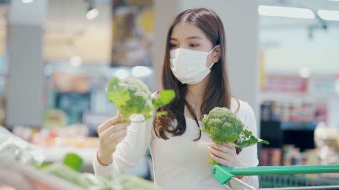 女人在超市挑选蔬菜