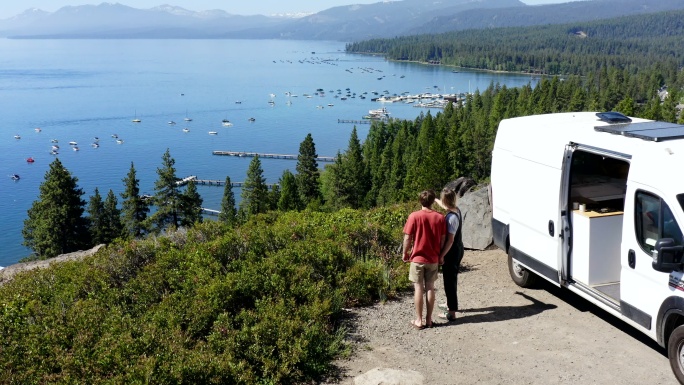年轻夫妇把面包车停在塔霍湖的一处风景区