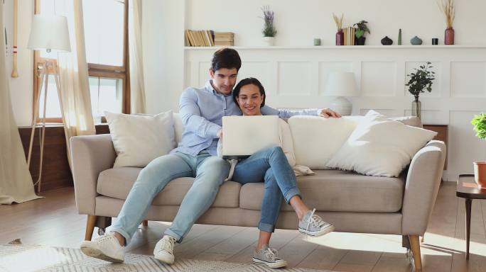 情侣在沙发上用电脑购物