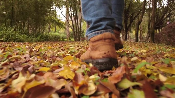 脚踩落叶秋天的脚步步伐特写慢动作