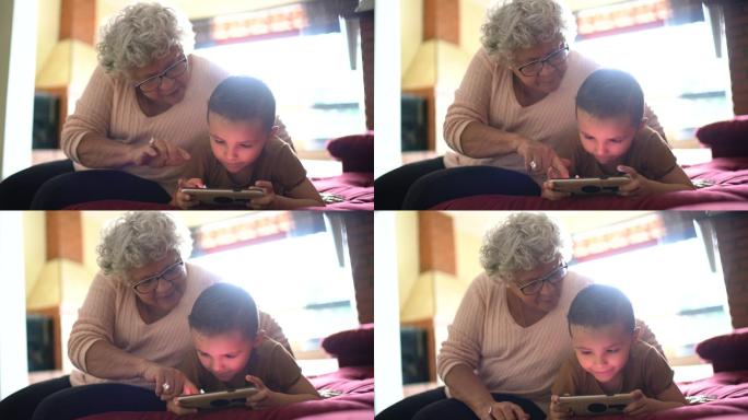 奶奶和孙子在家玩手机游戏